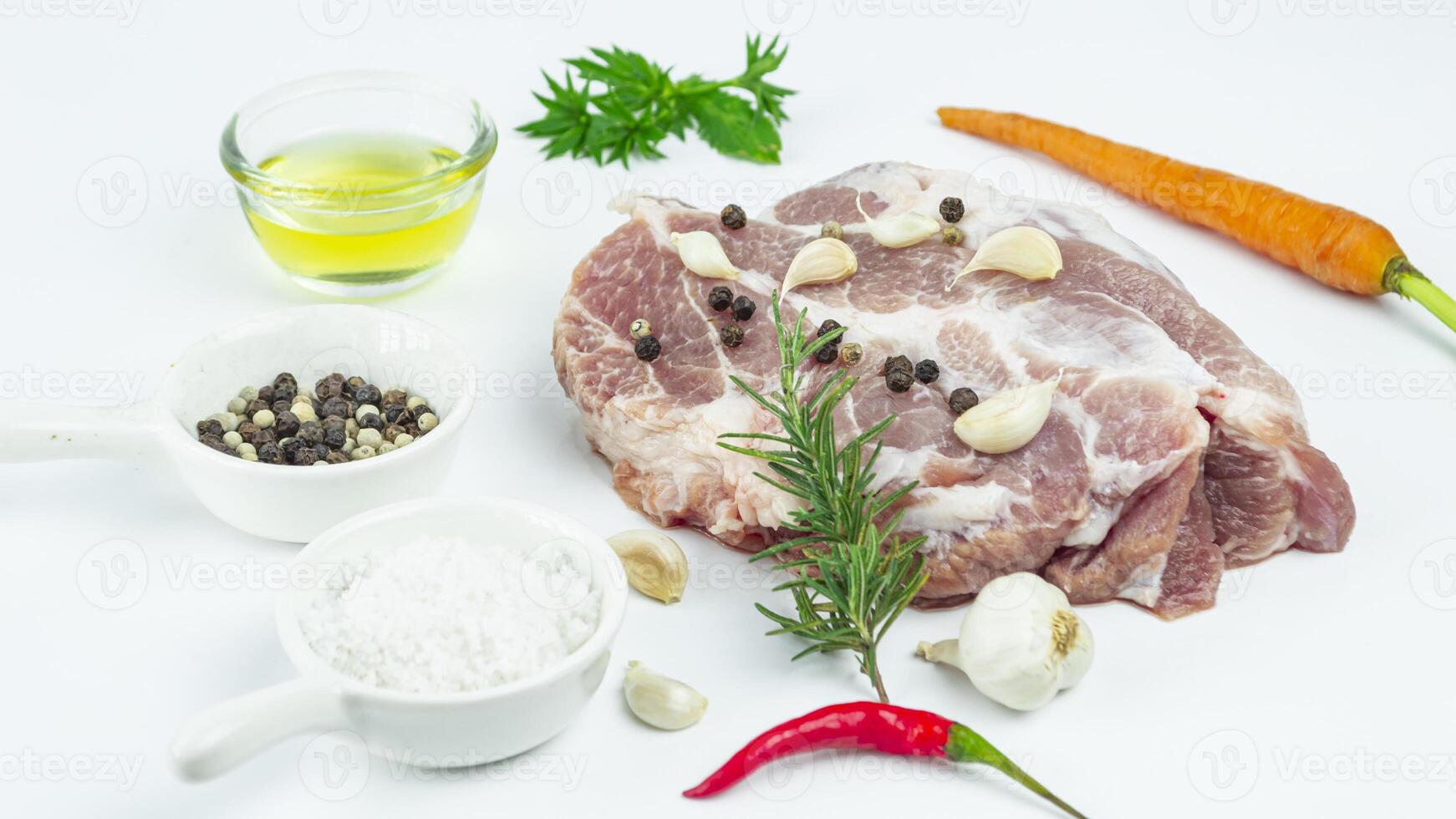 raw pork, carrots, herbs and spices on white background photo