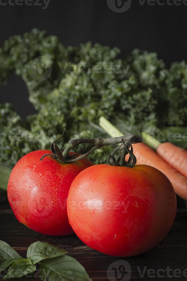 two tomatoes and a carrot on a table photo