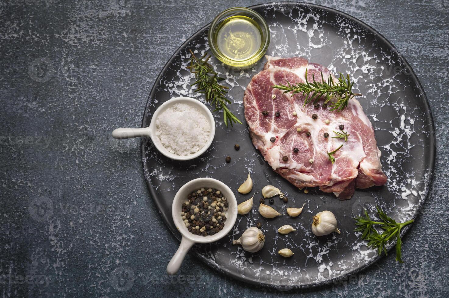 raw meat on a plate with spices and herbs photo