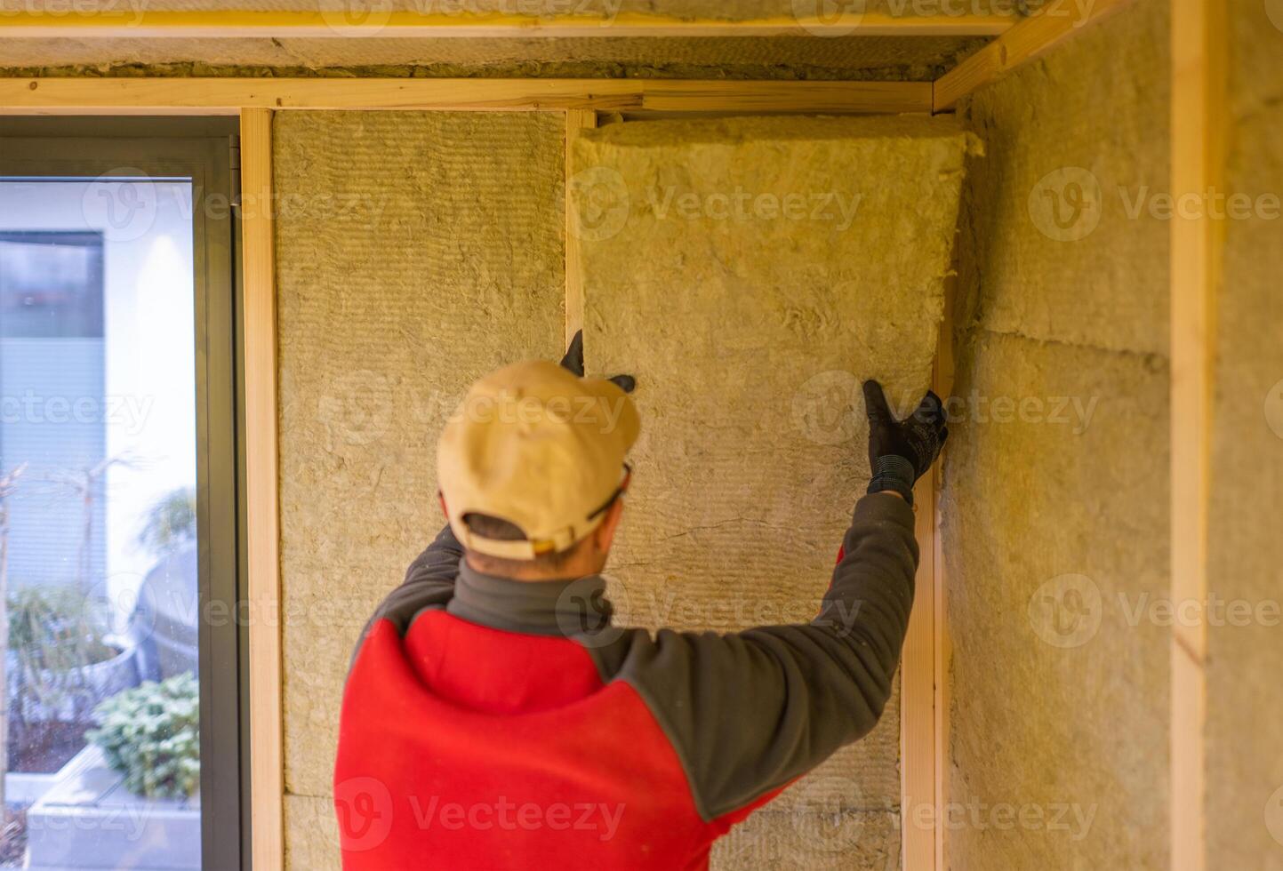 Construction Worker Installing Insulation in a Modern Home During Daylight photo