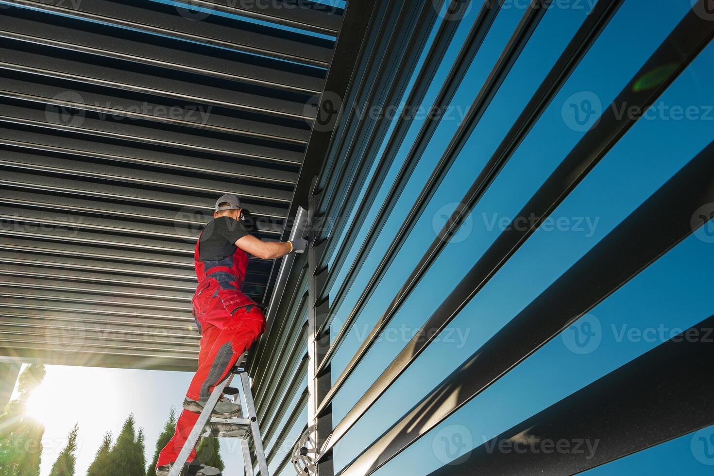 Technician on a ladder working on aluminium modern pergola photo