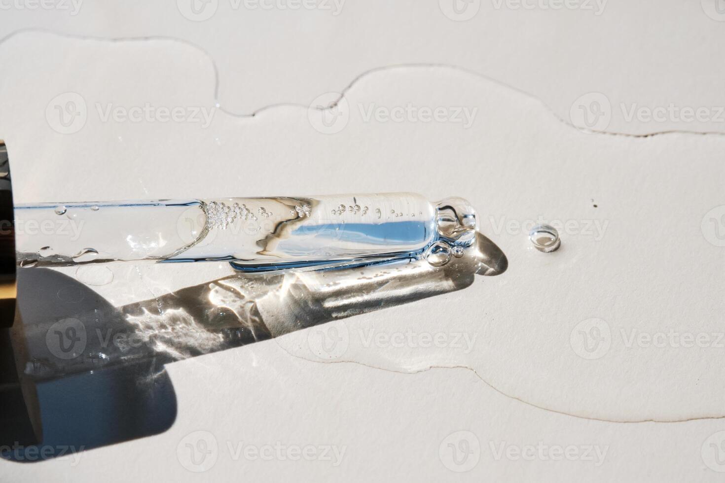 Pipette with serum on a beige background. photo