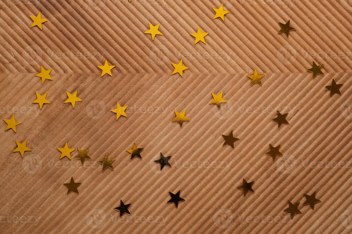 Abstract New Year and Christmas corrugated background in beige color with gold stars. photo