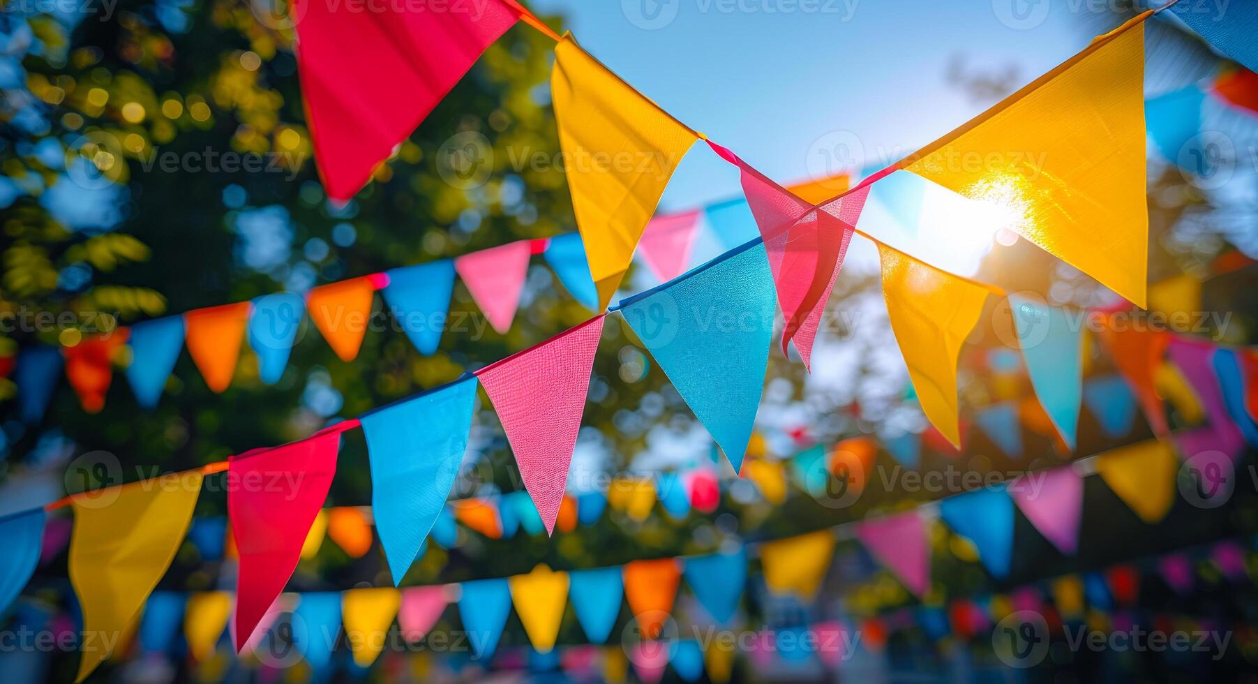 A bunch of colorful flags hanging in the air. The flags are of different colors and sizes, creating a vibrant and lively atmosphere. The scene suggests a celebration or a festive event photo