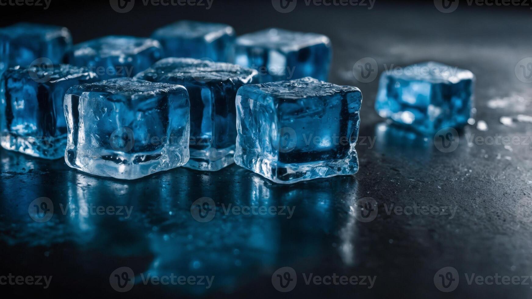 The striking blue ice cubes create a mirror like reflection on a sleek black table offering an eye catching image with ample copy space. photo