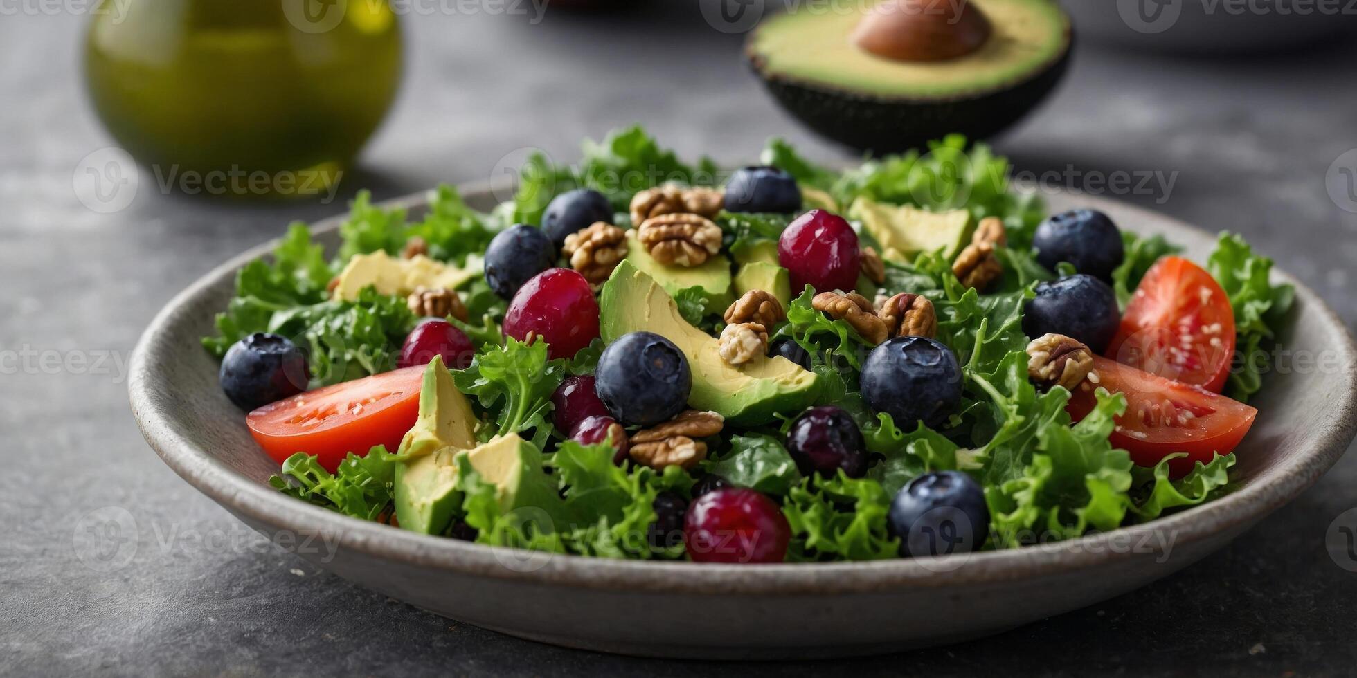 A colorful salad packed with antioxidant superfoods like kale blueberries and walnuts tossed in a tangy avocado oil dressing. photo
