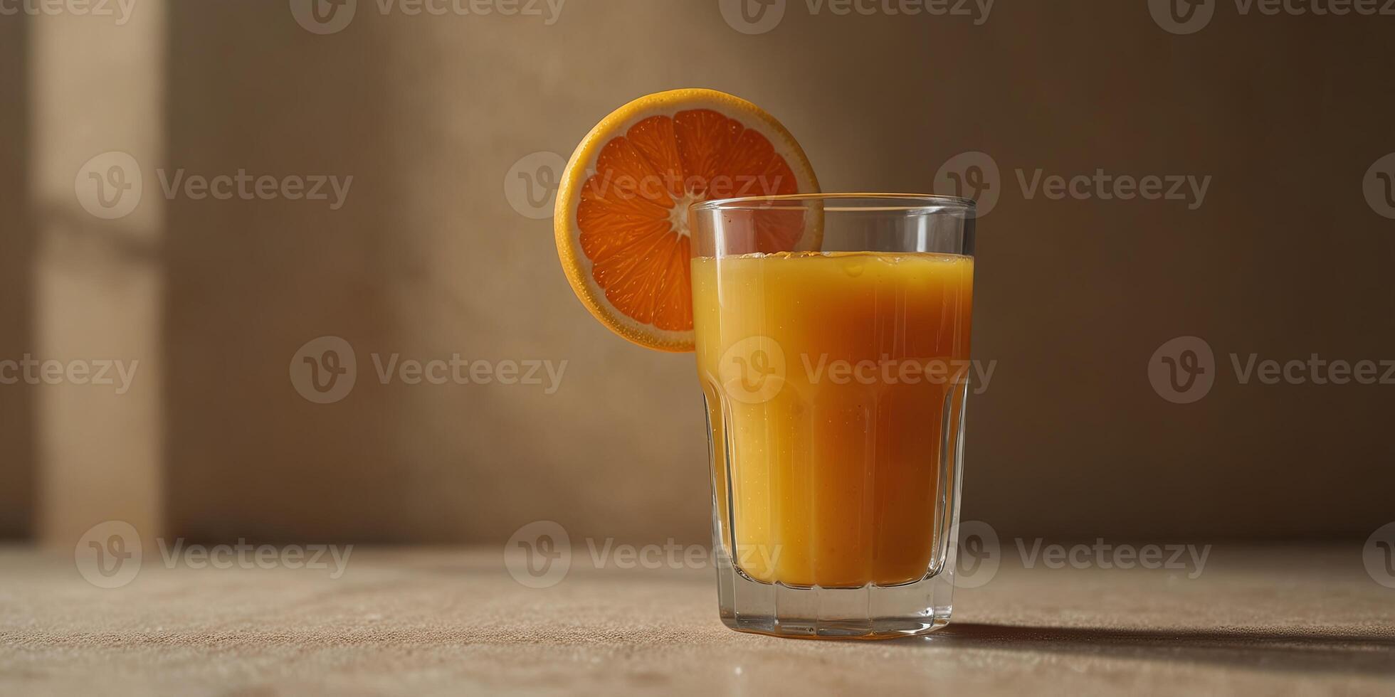 Glass of fresh orange juice on a beige background, shadow play Refreshing drink concept. photo