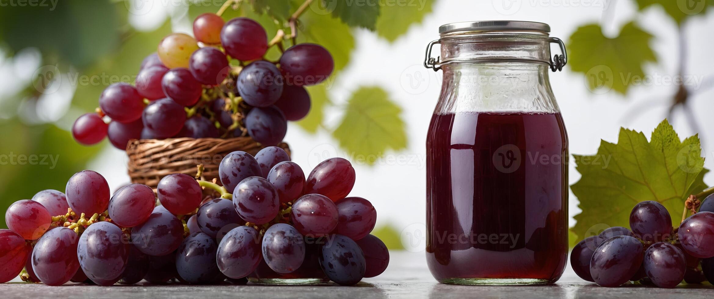 a glas jar filled with grape juice surrounded by red grapes on a white studio background. photo