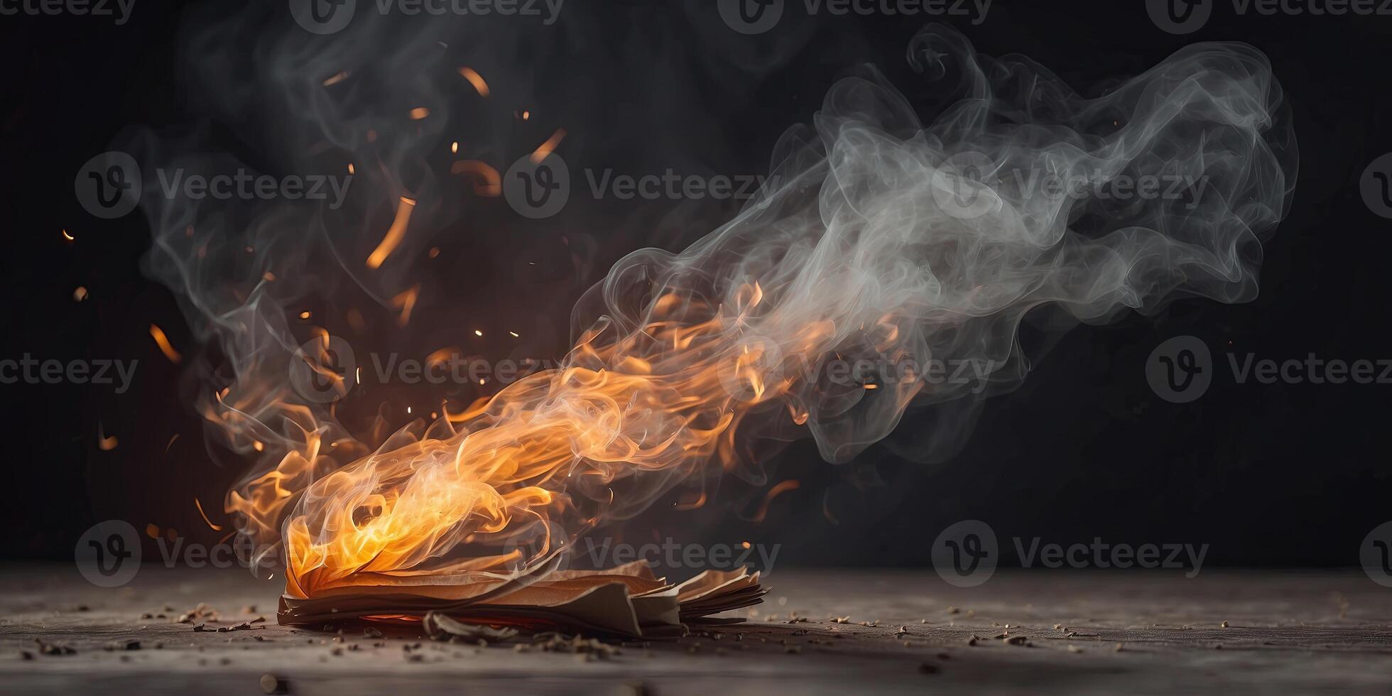 Burning paper surrounded by sparks and smoke, abstract concept. photo