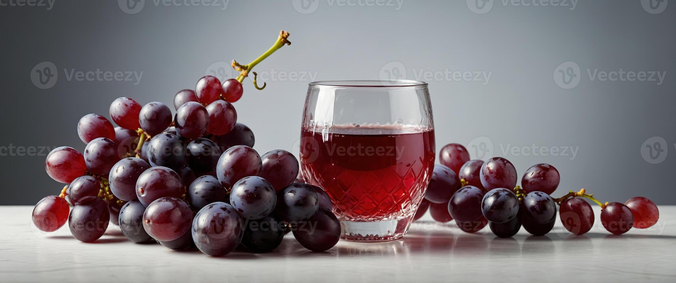 a glas jar filled with grape juice surrounded by red grapes on a white studio background. photo