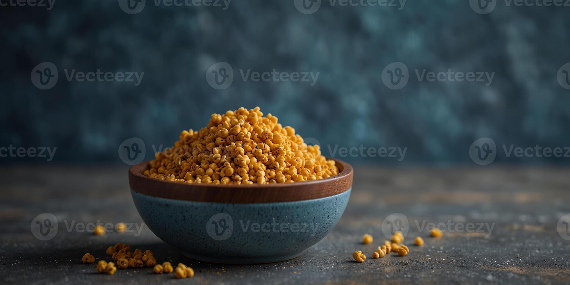 Wooden bowl filled with bee pollen on a blue concrete background suitable for healthy nutrition with space for additional images. photo