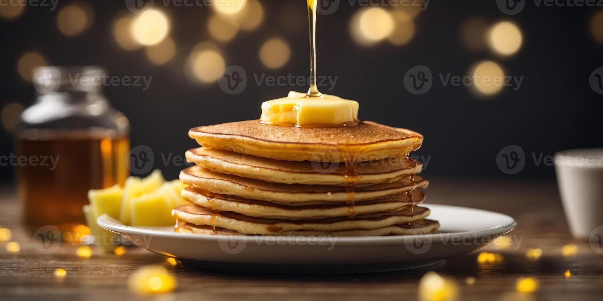A stack of pancakes next to a bowl of butter and a syrup cup. photo