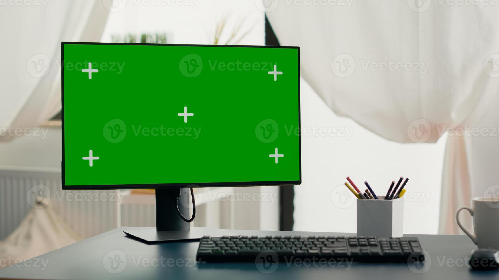 Powerful computer with chroma key green screen mock up stands on desk in living room. Pc with isolated display in home office with nobody in is ready for online business meeting photo