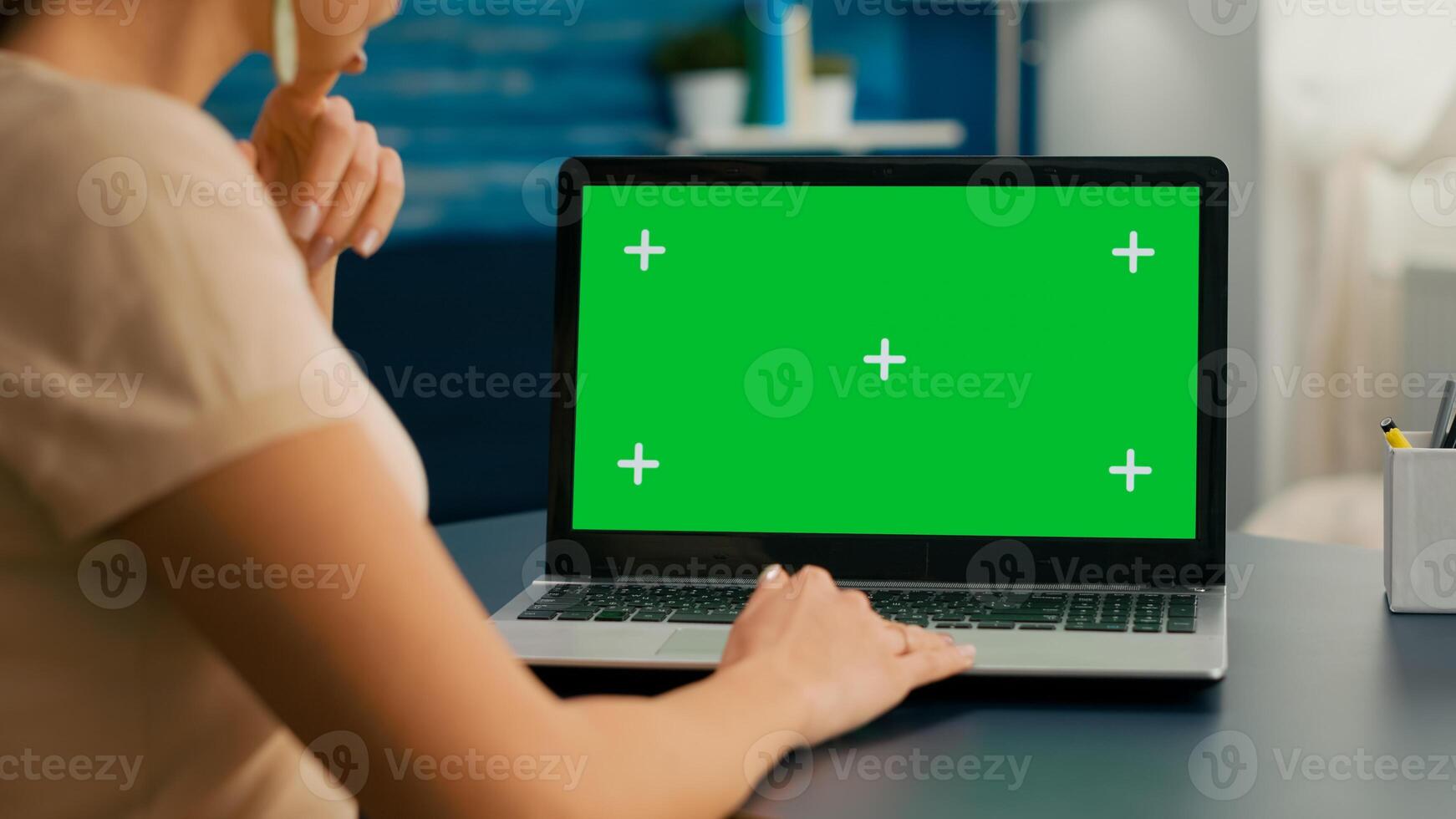Close up of freelencer typing on isolated laptop for business commerce. Caucasian woman working on computer with mock up green screen chroma key display in home office studio. photo