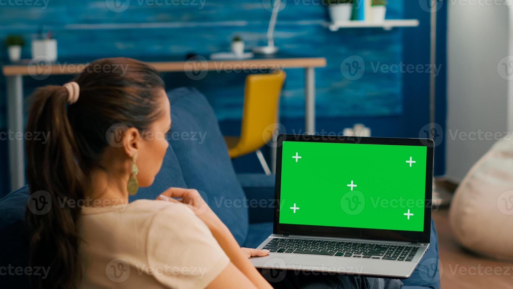 Freelancer sitting on couch working on business ideas using laptop computer with mock up green screen chroma key display. Caucasian female searching the network use isolated pc photo