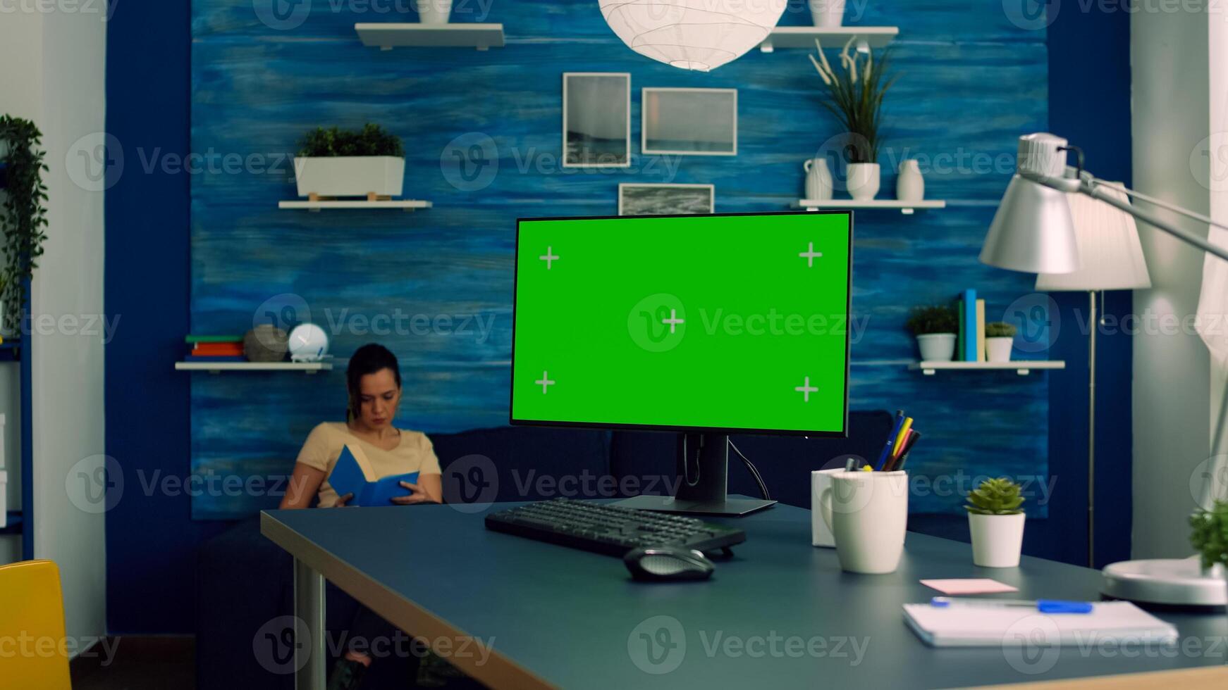 Freelancer working on powerful computer with mock up green screen chroma key display sitting on desk table. Caucasian female looking for business nformation on network using isolated pc photo