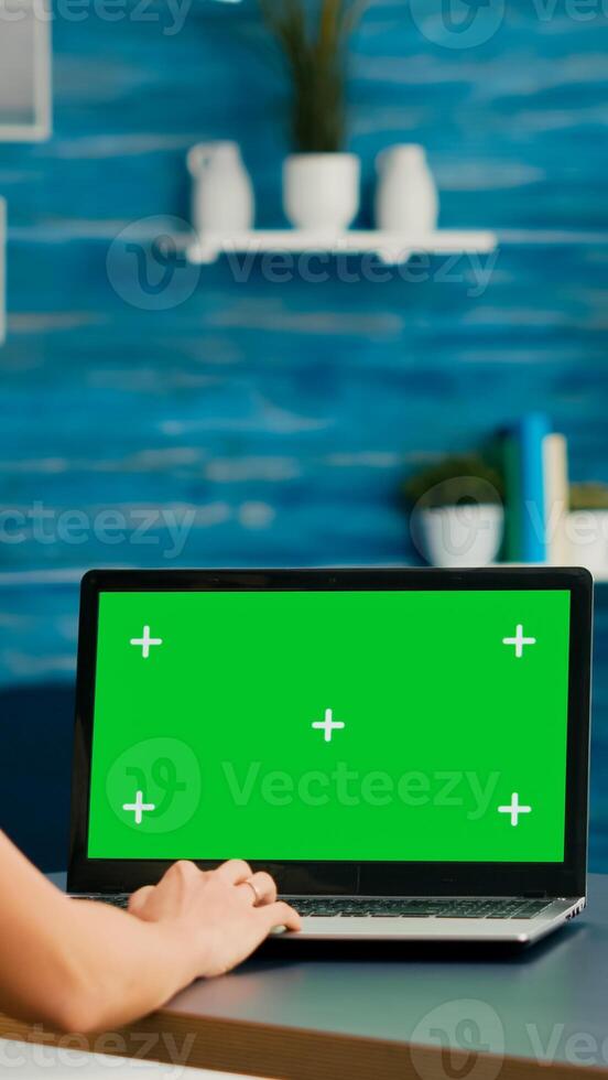 Freelancer woman searching business advertising using isolated pc standing in home office studio. Caucasian woman working with laptop computer with mock up green screen chroma key photo