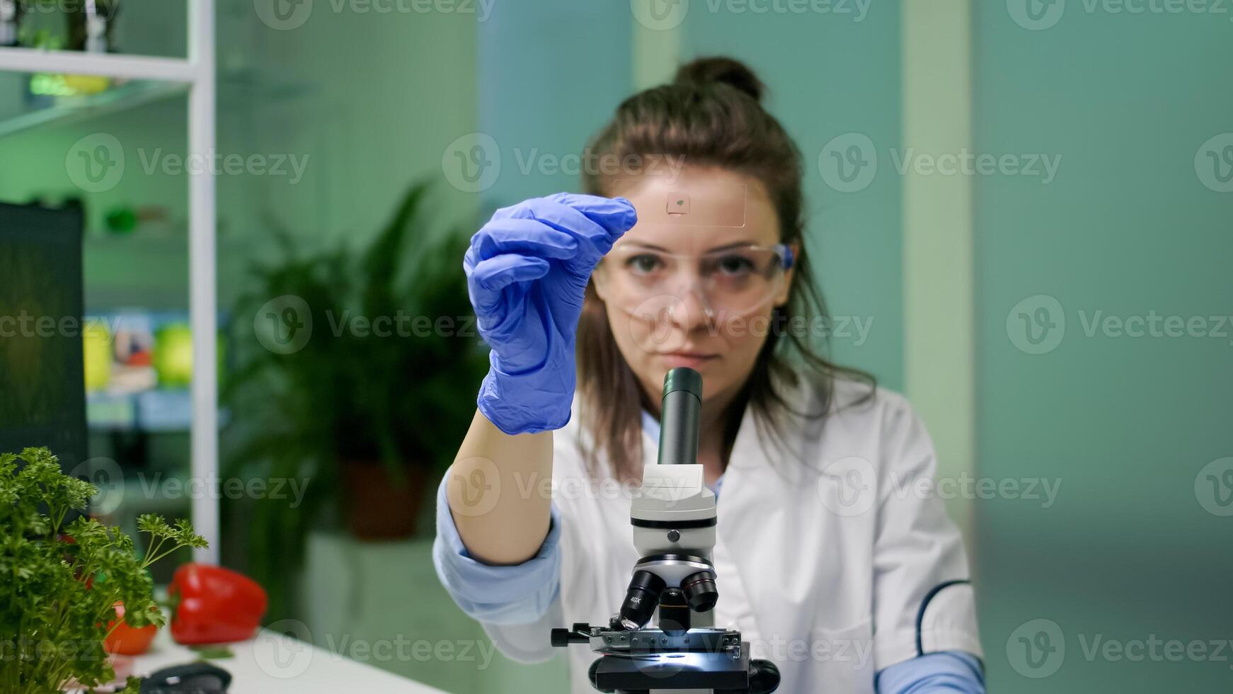 Biochemistry scientist analyzing green liquid sample using microscope for biochemistry experiment. Biologist woman working in pharmaceutical laboratory discovering gmo expertise photo