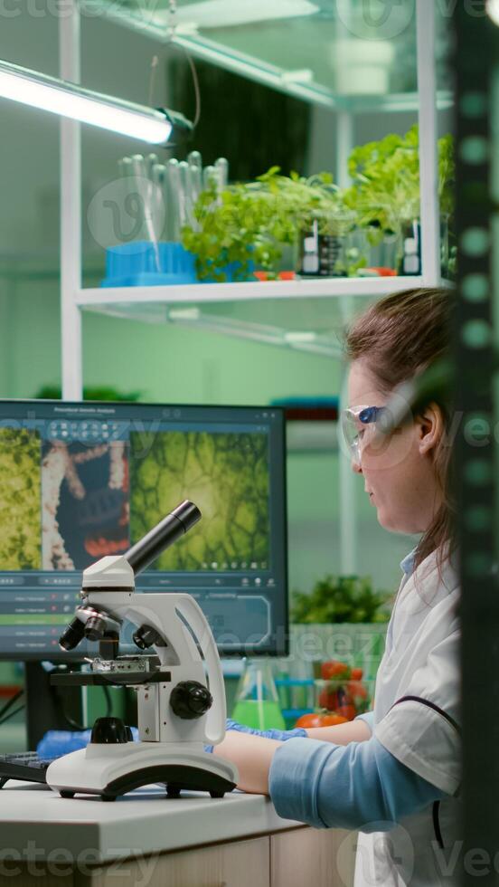 Biochemistry doctor examining chemical test using microscope for genetic researcher. Biologist specialist discovery organic gmo plants while working in microbiology food laboratory photo