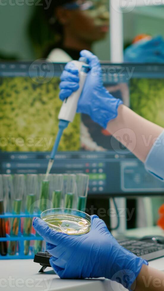 Scientist woman taking genetic solution from test tube with micropipette putting in petri dish analyzing medical expertise. Biologist researcher working in pharmaceutical laboratory photo