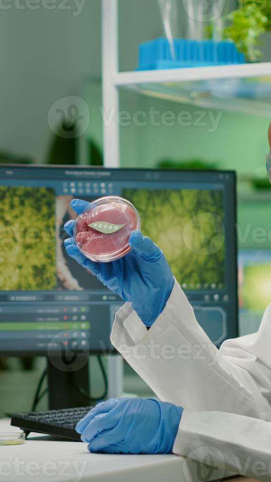Chemist researcher typing microbiology expertise of vegan beef meat. Biochemist woman researching vegetareian food modified genetically working at biochemistry experiment in chemistry laboratory photo