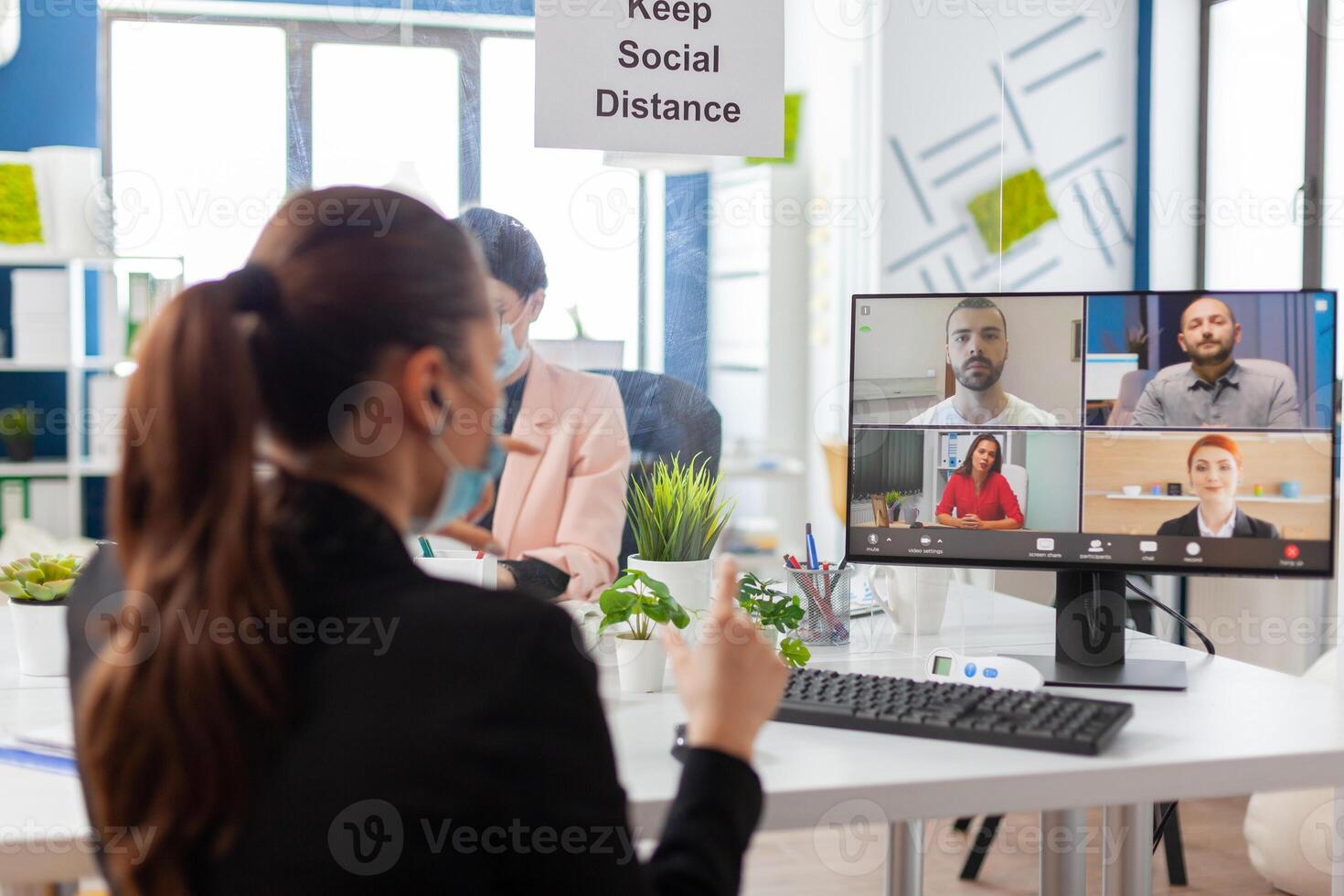 Entrepreneur woman on remote conference discussion in new normal workplace during global pandemic with covid19 flu, wearing face mask keeping social distancing. Internet web videocall chat online talk photo