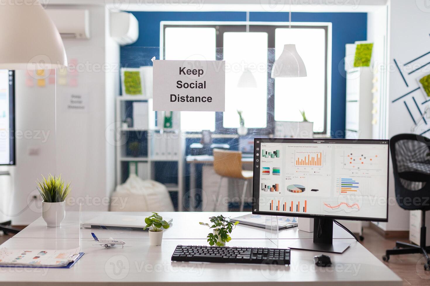 Empty startup corporate office with nobody in it is ready for financial company meeting during global pandemic. Business chart on computer screen. Workplace with modern furniture, documents on table photo