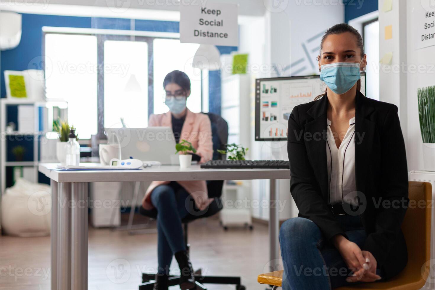 Portrait of manager wearing medical face mask against coronavirus working in startup company office. Teamwork planning management presentation analyzing business strategy during global pandemic photo