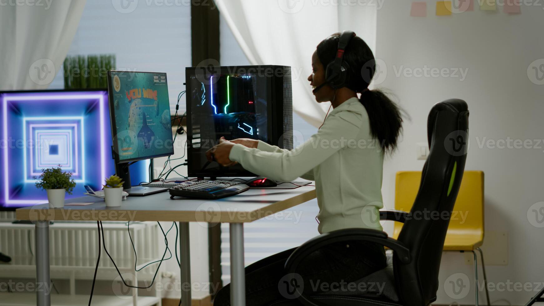 Winner black gamer sitting on gaming chair playing space shooter games with wireless controller. Pro cyber man streaming online videogames for esport tournament on RGB powerful personal computer photo