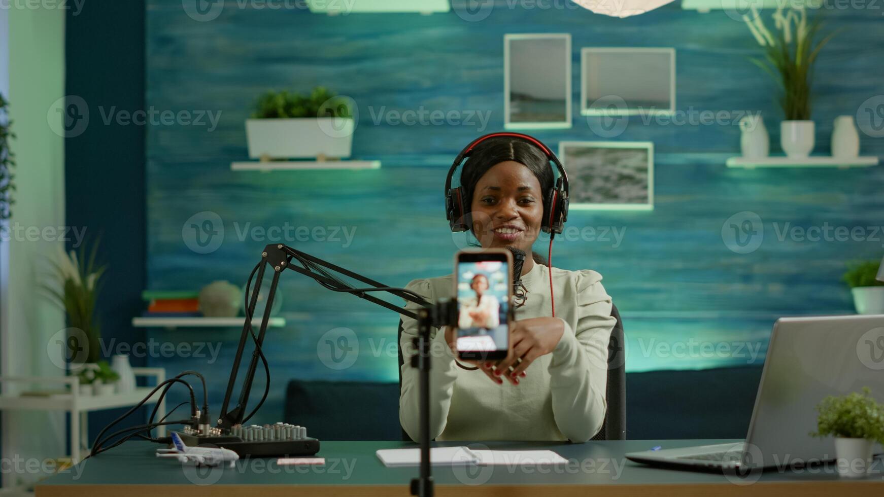 Black influencer in entertainment industry talking and checking sound during broadcast from home studio. On-air online production internet podcast show host streaming live content for social media photo