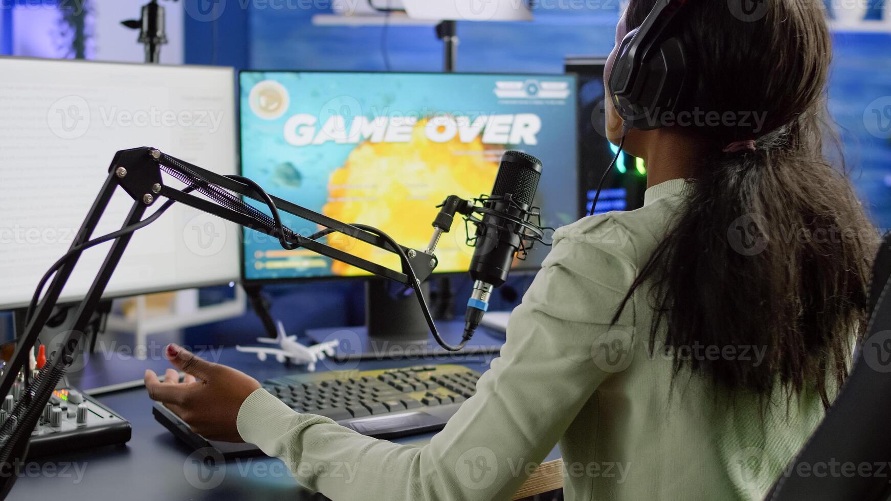Pro cyber streamer losing videogame tournament while wearing professional headset talking on stream chat. Defeated gamer using RGB powerfull computer for online competition late at night in gaming room photo