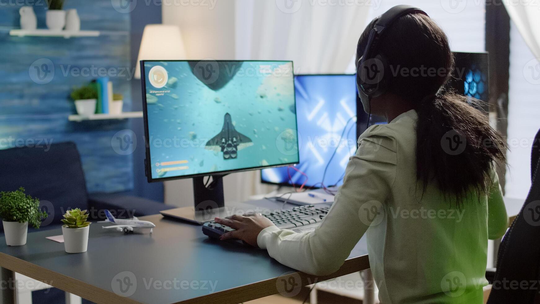 African cyber gamer putting on headset before playing online games using RGB keyboard and mouse. Player performing online games on powerful computer during gaming tournament photo