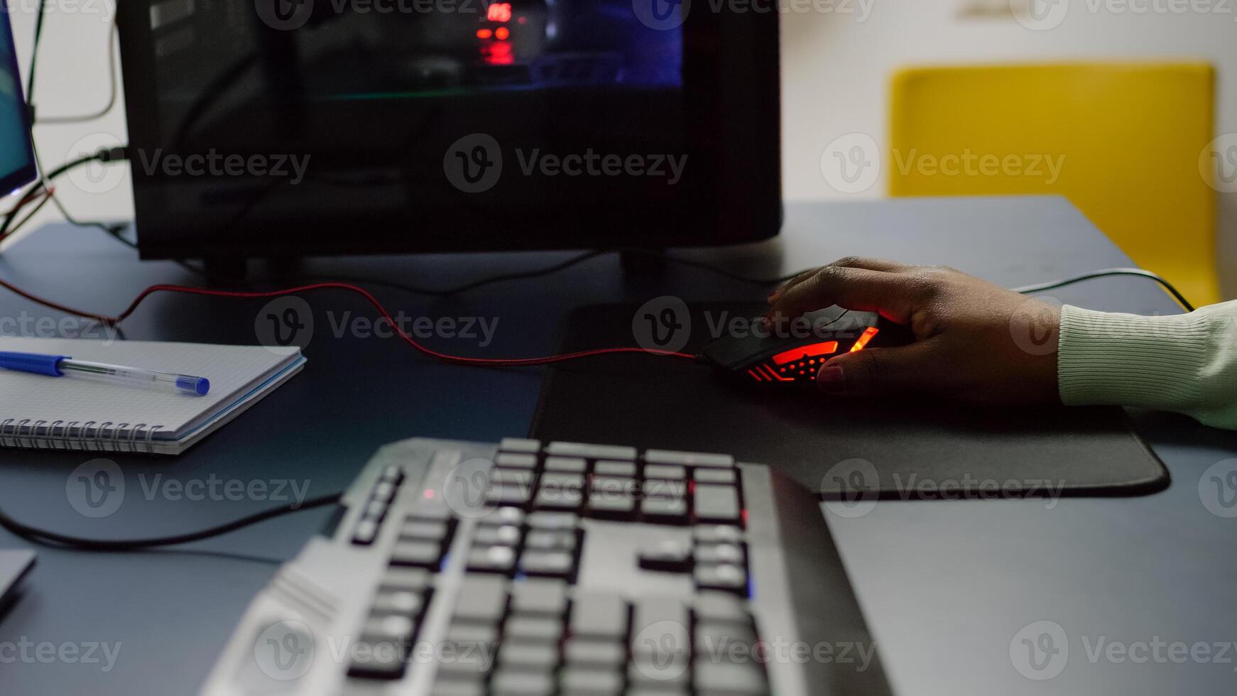 Close up of streamer holding RGB mouse playing space shooter videogame. Pro cyber african woman gaming in home studio for online esports competition on professional powerful computer photo