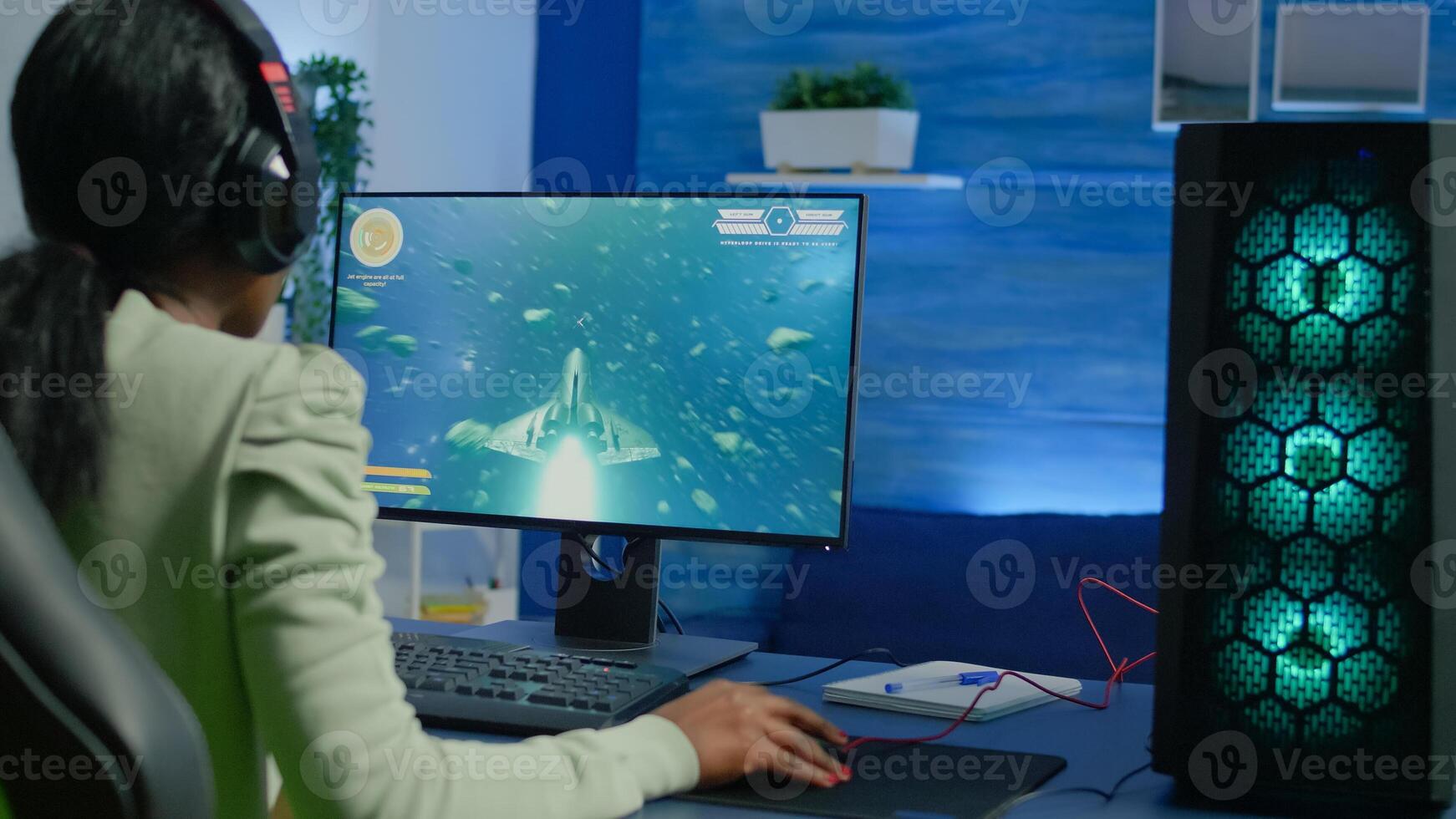 Addicted african gamer performing cyber games using professional headphones in gaming room. Competitive gamer playing space shooter game tournament with new graphics on powerful computer. photo