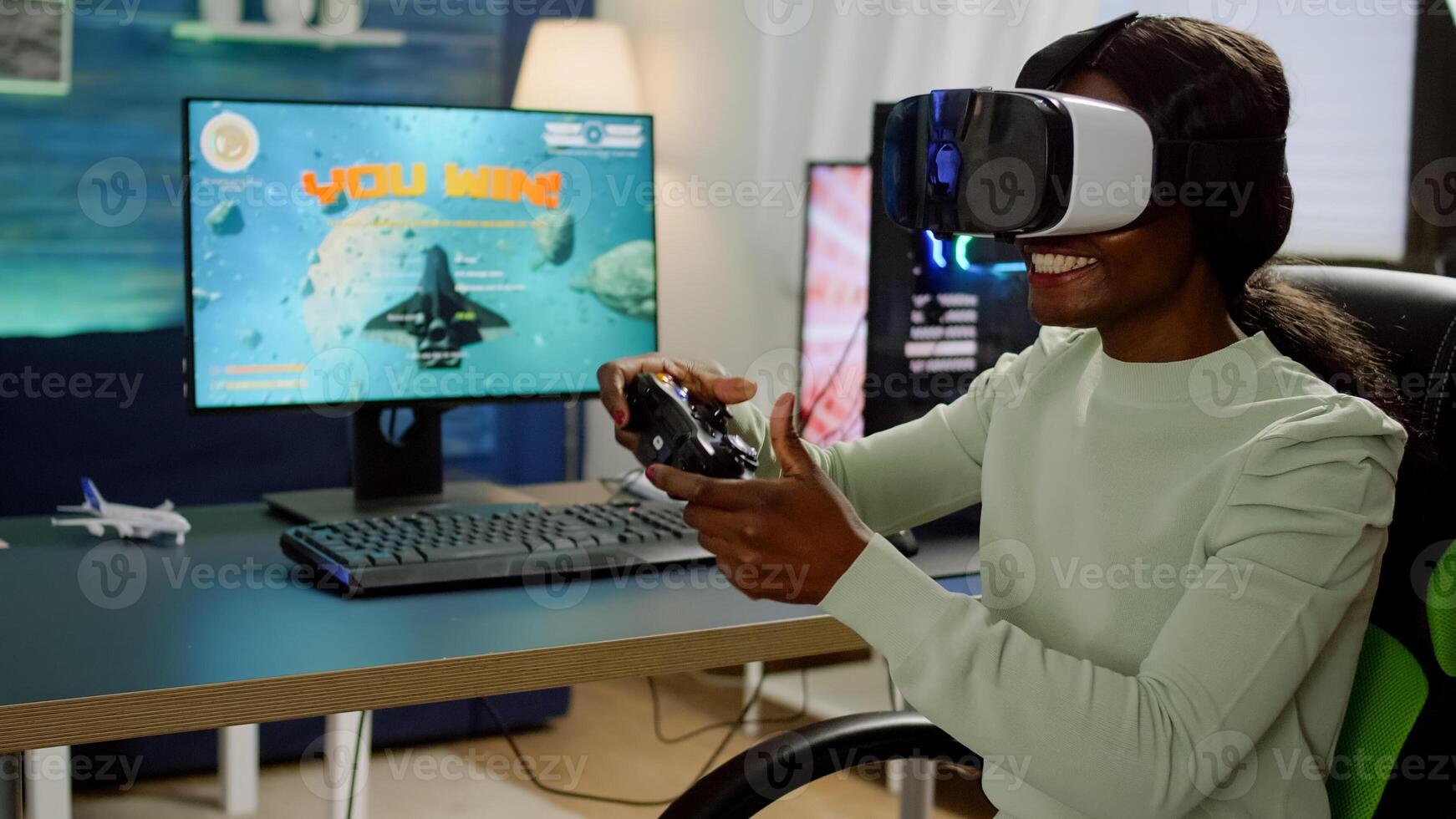 African player woman wining space shooter game using virtual reality goggles playing games with joystick. Pro cyber gamer streaming online videogames with new graphics on RGB powerful computer photo