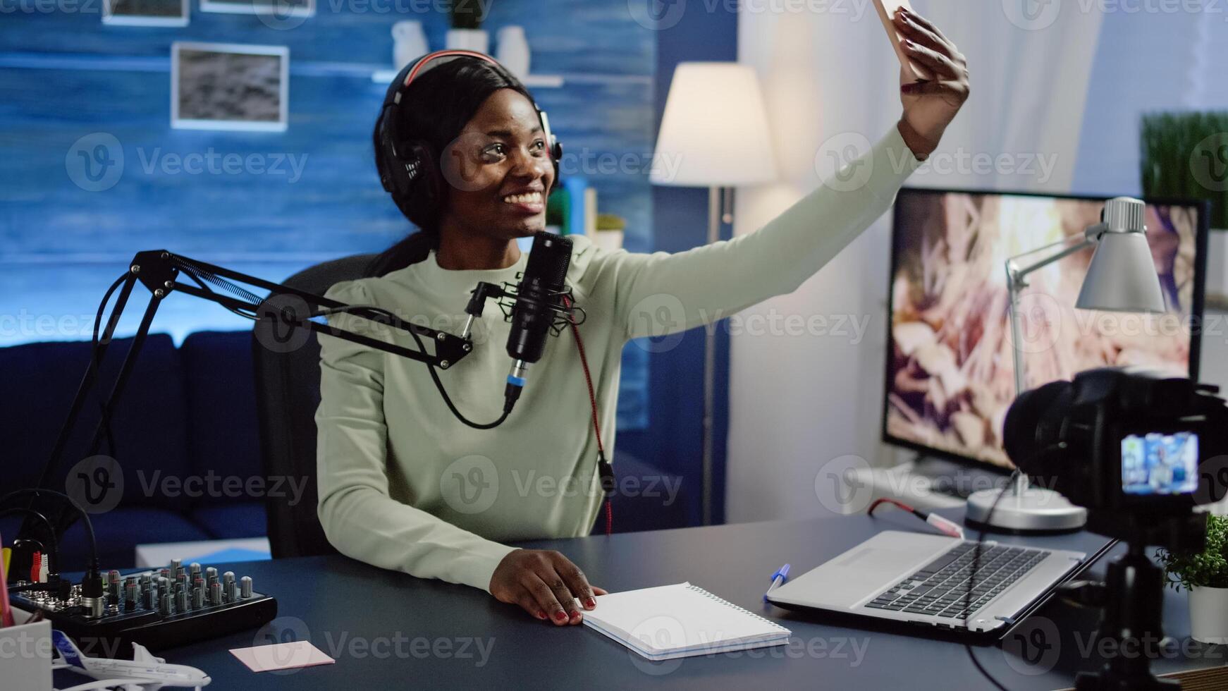 African woman blogger, vlogger portrait taking pictures of herself on smartphone. Content creator, on-air online production internet broadcast show host streaming live content for social media. photo