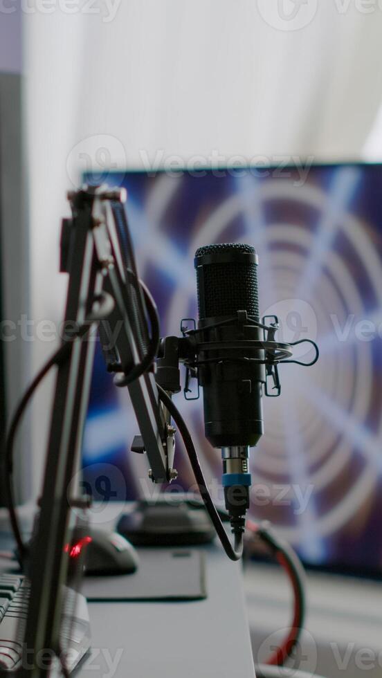 Game loading on display of RGB professional powerful computer and stream chat is prepared for virtual tournament. Streaming professsional microphone in empty gaming home studio with neon lights. photo