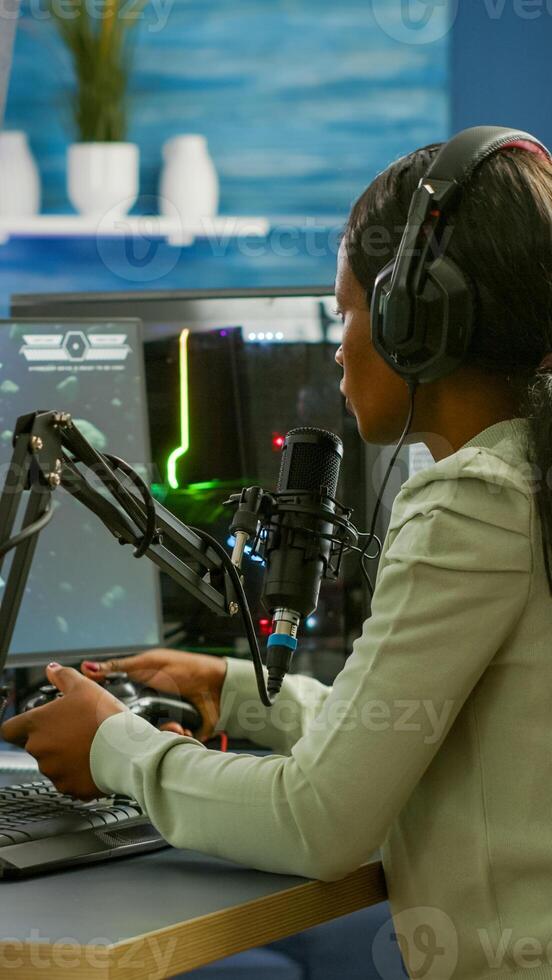 Sad african e sports streaming after losing online competition covering face wearing headphones holding joypad. Pro gamer streaming online games with new graphics on RGB powerful computer. photo