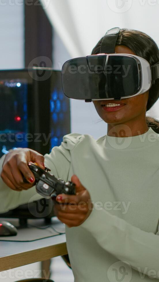 Winner player holding joystick playing videogame in gaming room using virtual reality. Professional pro gamer streaming online videogames with new graphics on powerful computer using modern equipment. photo