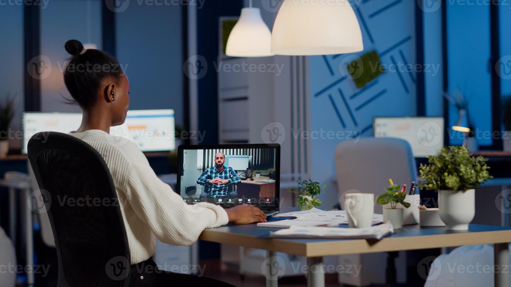 African manager with headphones waving at camera talking with remote disabled employee, overworking using laptop. Woman working in start up financial company havig online meeting, virtual discussing photo
