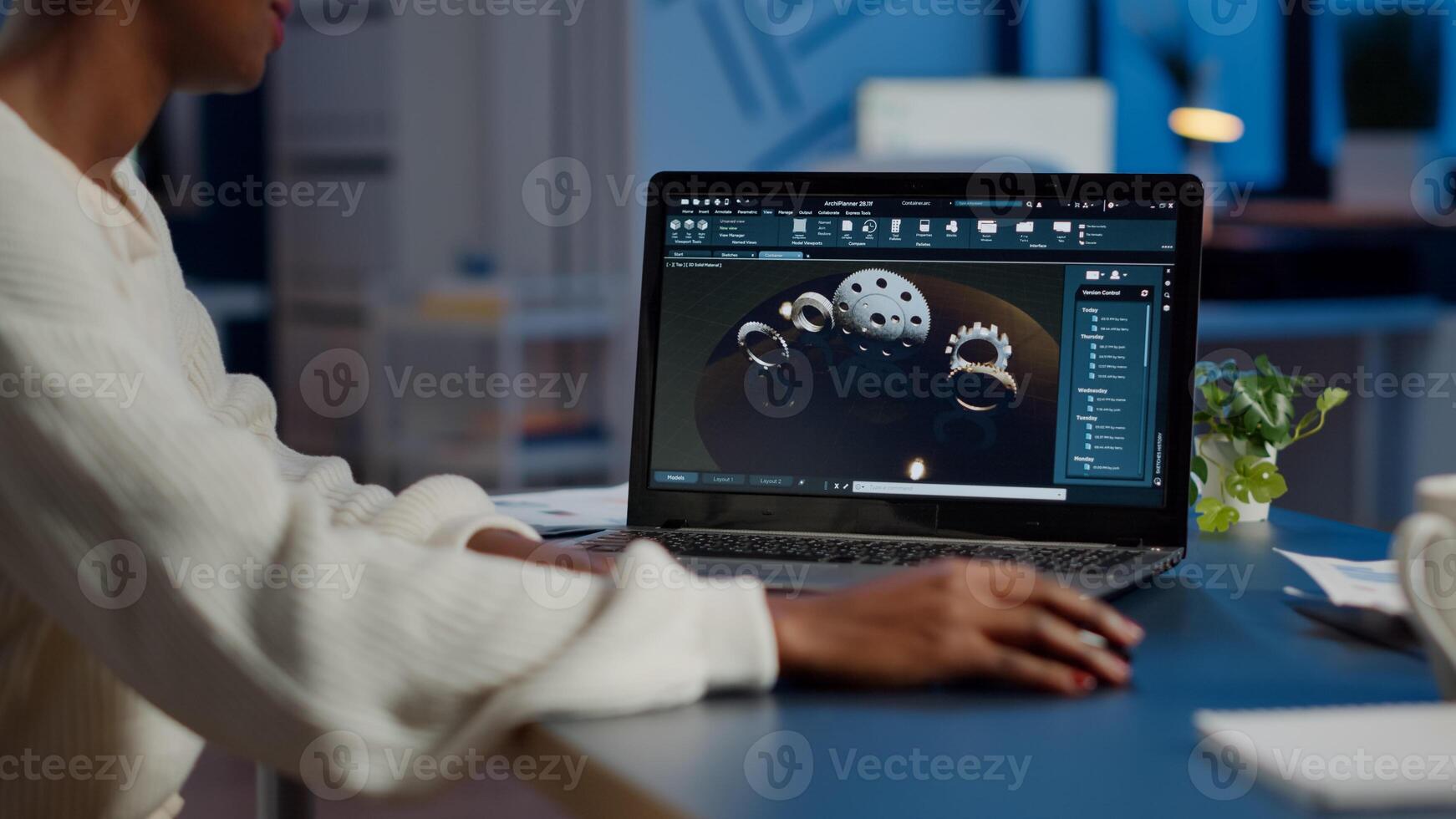 African woman engineer working at new project using laptop doing overtime at night sitting at desk in start-up office. Industrial construction designer studying on pc showing cad software in midnight photo