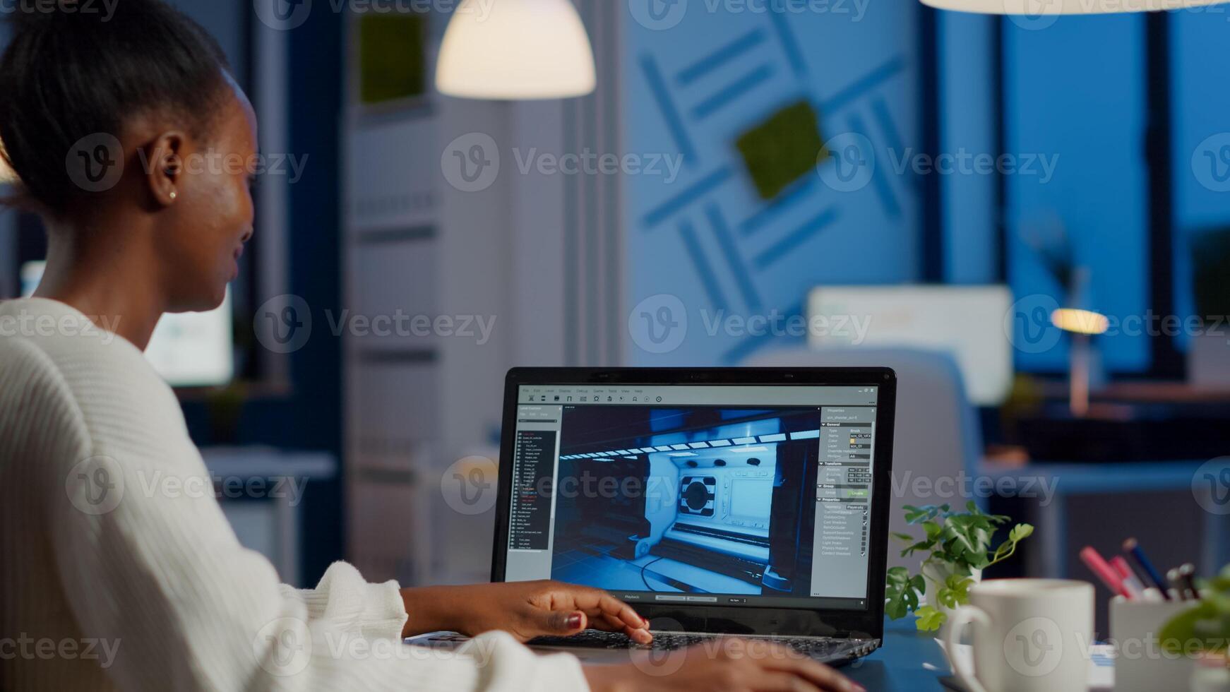 African gamer creator testing game over level interface, developing new design in midnight from business office using laptop. Player testing online games with technology network wireless. photo