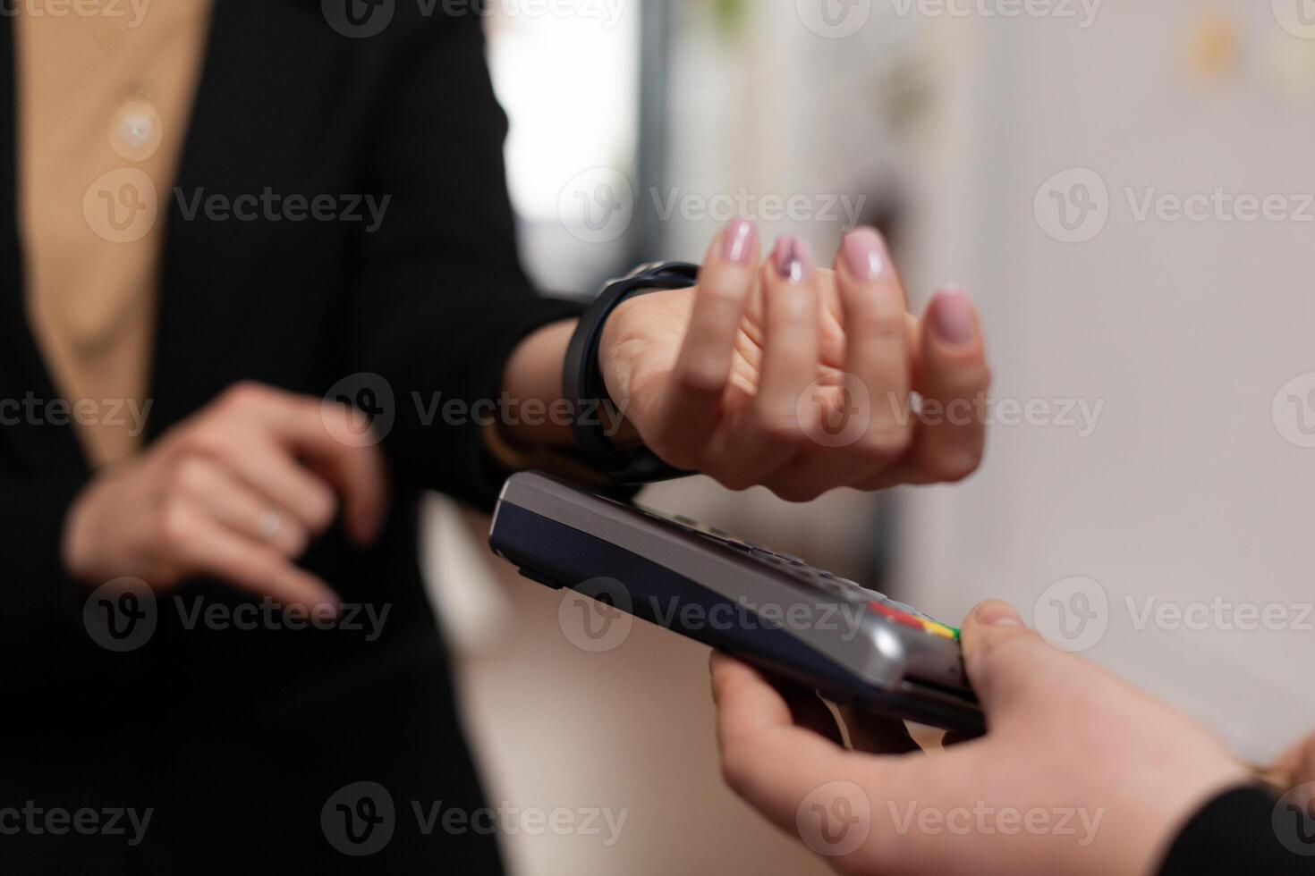 Close up shot of woman entrepreneur paying delivery food from restaurant, using smartwatch over pos. Using modern technology for money transcation in modern workplace. photo