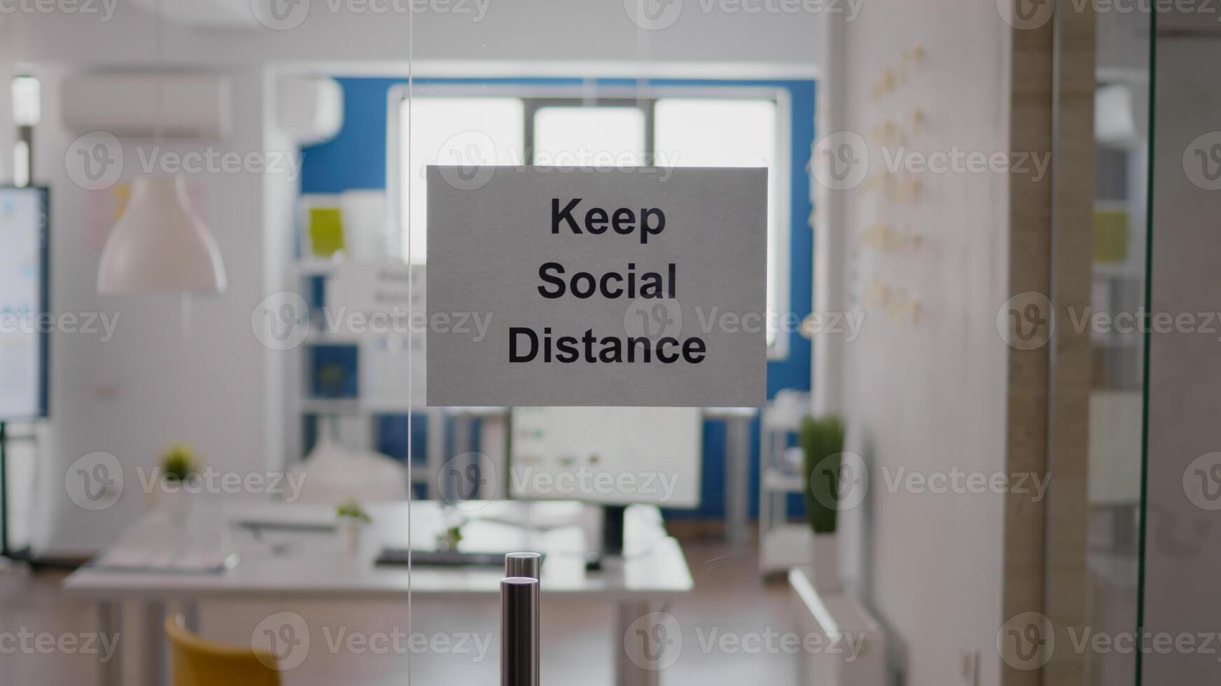 Business glass interior office with keep social distance sign on the wall. Modern office space with nobody in it during global pandemic, coronavirus crisis photo