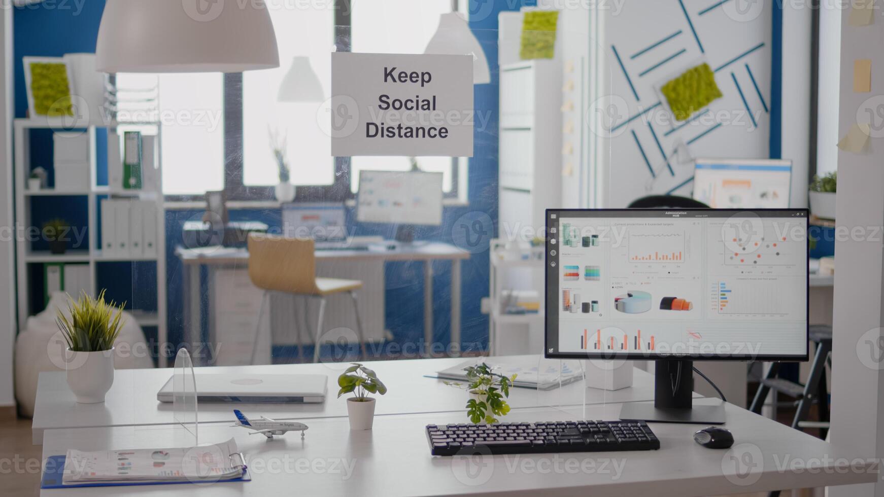 Financial business graphs in empty office with nobody in it, keep social distance signs on the wall. Plastic separators during coronavirus covid 19 economy health crisis photo