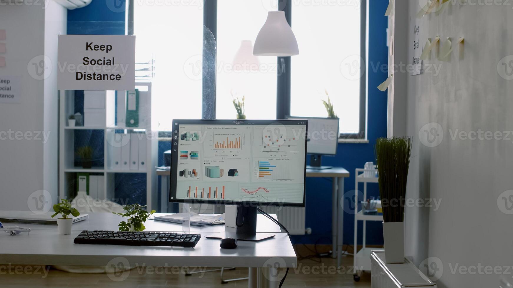 Keep social distance poster on plastic separator in empty modern office with nobody in it during covid 19 coronavirus global outbreak. Working business space photo