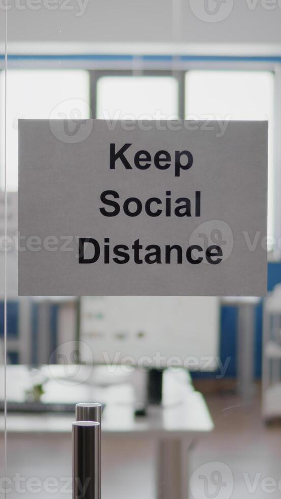 Business glass interior office with keep social distance sign on the wall. Modern office space with nobody in it during global pandemic, coronavirus crisis photo