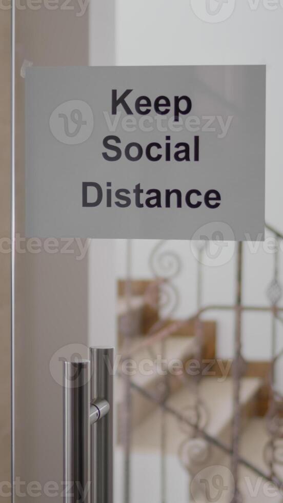 Glass office dor with keep social distance poster on it, modern office stairs duting covid 19 coronavirus pandemic, global economic crisis photo