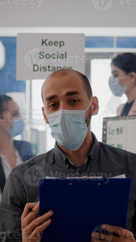 Pov of businessman in face mask to avoid infection talking on online call conference duting zoom meeting. Entrepreneur working safety in new normal office photo