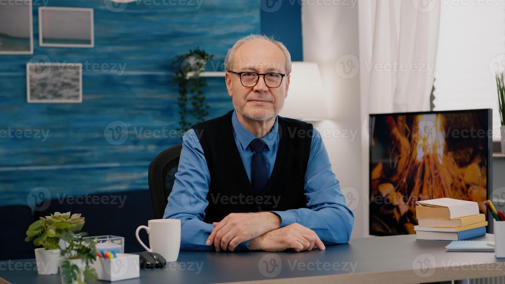 Portrait of senior man chatting and listening remote teamwork during call working from home. An elderly person using internet online chat technology webcam making virtual meeting call connection photo